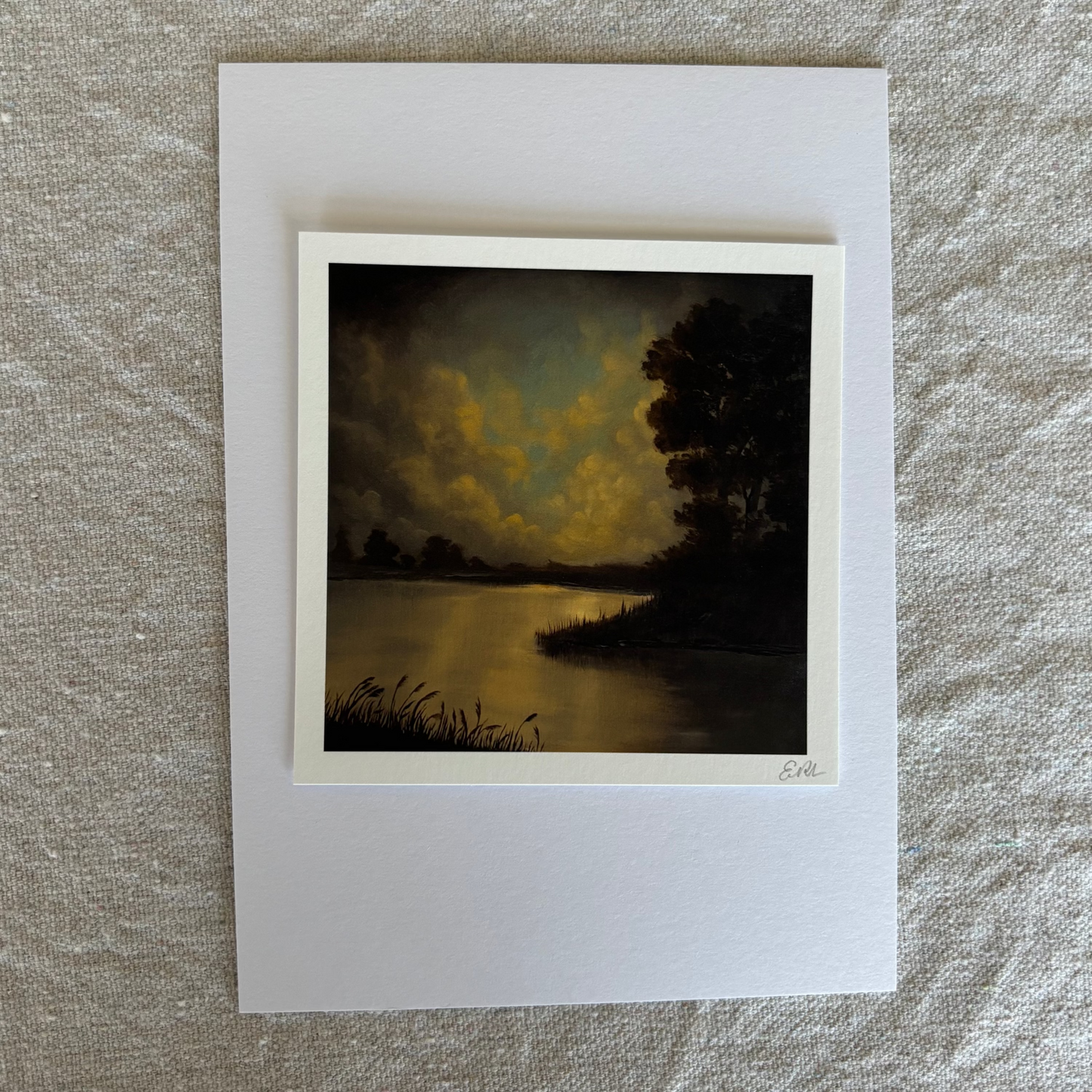 Small print of a landscape with a lake and trees on a textured beige surface