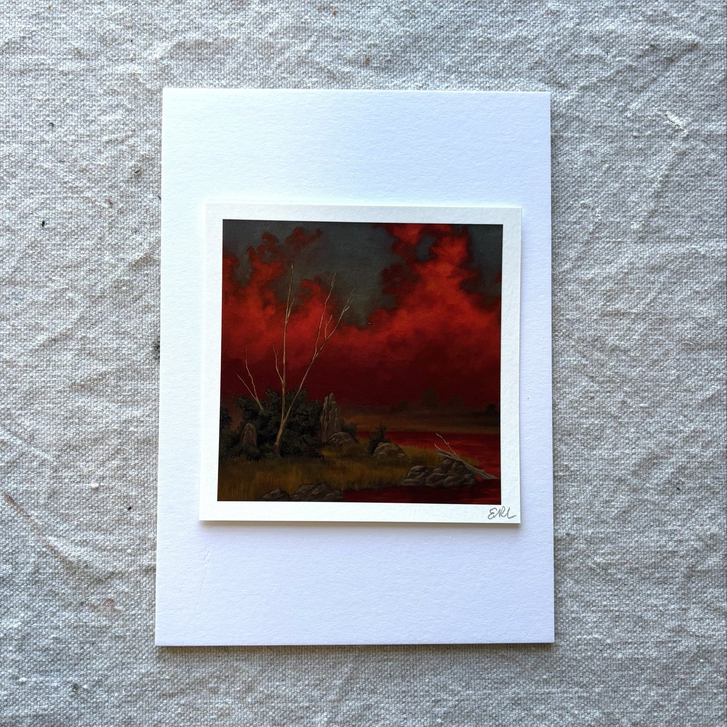 Art print of a fiery landscape with a white border on a textured gray background
