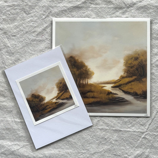 Two landscape prints on a textured gray surface