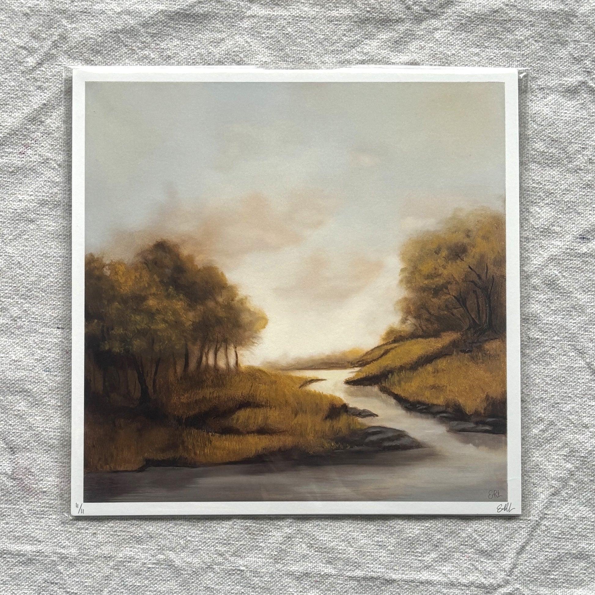 Print of a landscape with trees and a river on a textured gray background