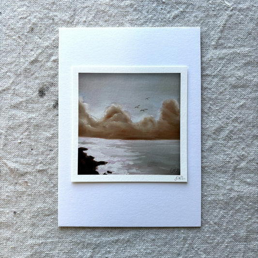 art print of a landscape with a body of water and clouds on a textured gray background