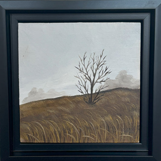 Framed artwork of a tree on a hillside with a black frame.