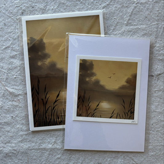 Two art prints with a sunset design on a textured surface